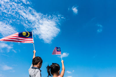 Low angle view of flag against blue sky