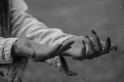 Cropped image of woman hands enjoying rain