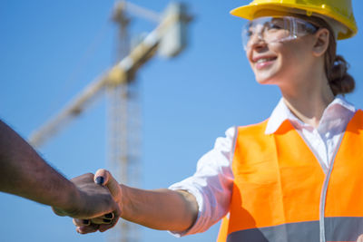 Low angle view of smiling mid adult man against clear sky