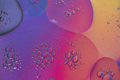 Top view oil bubbles drop on the water with colorful background, macro photography concept