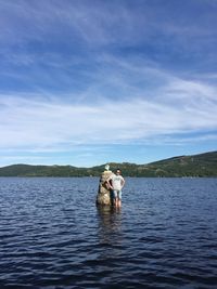 Man in boat on lake against sky