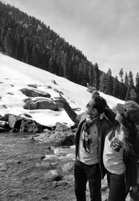 People standing on snow covered landscape against sky
