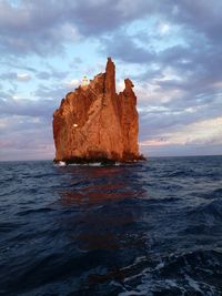 Rock formation in sea against sky