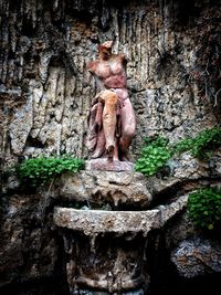 Close-up of old statue against wall