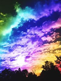 Low angle view of silhouette trees against dramatic sky