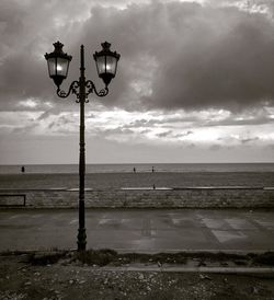 Street light on beach against sky