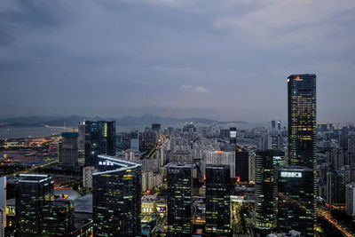 Illuminated cityscape against sky at dusk