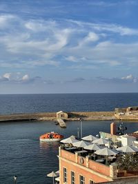 High angle view of buildings by sea against sky