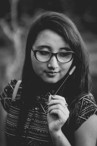 Close-up portrait of young woman smoking outdoors