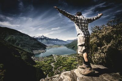 Woman standing by mountain range against sky