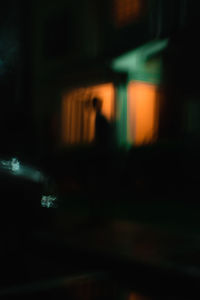 Defocused image of person walking on road at night