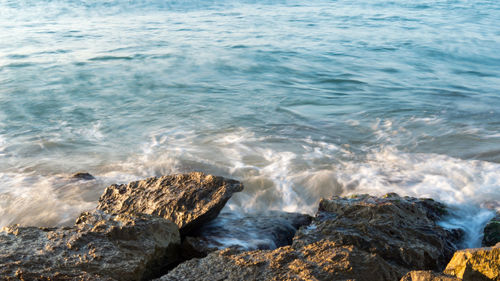 High angle view of waves breaking on rocks