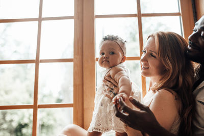 Mother and daughter against window