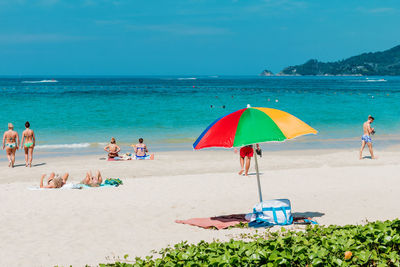 People at beach against sky