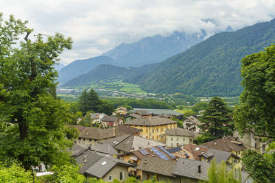 Houses by trees and mountains against sky