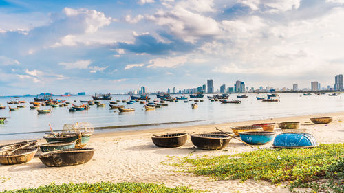 Boats moored on beach against sky