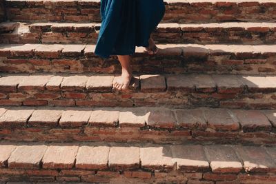 Low section of man moving down on steps