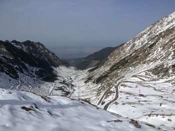 Snow covered landscape with mountain range in background