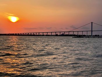 Silhouette pier over sea against sky during sunset