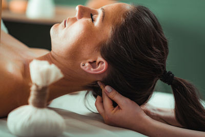 Kizhi or herbal bolus bags ayurveda massage in a beauty salon, therapist pressing herbal bolus 