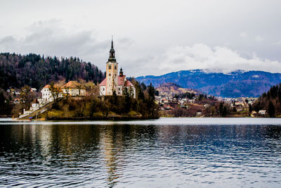 Scenic view of lake by buildings against sky