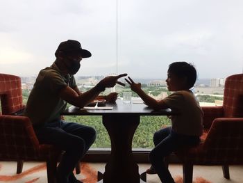 Side view of people sitting on seat