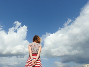 Rear view of woman standing against sky