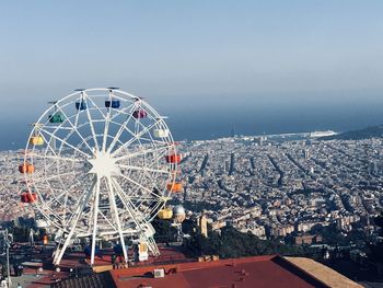 Ferris wheel in city against clear sky