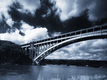 Low angle view of bridge against cloudy sky