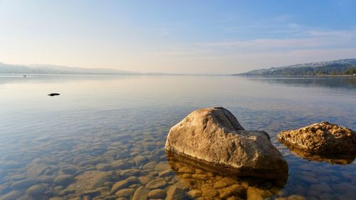 Scenic view of rocks in sea against sky