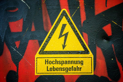 Close-up of yellow high voltage sign