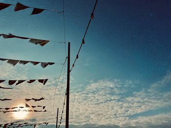 Low angle view of flags hanging against blue sky