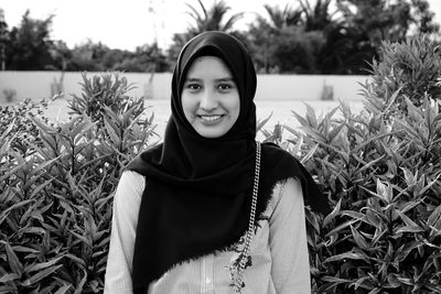 Portrait of smiling young woman standing in field