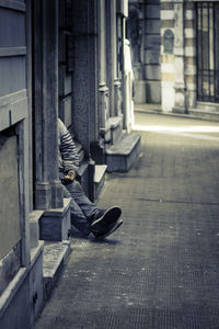 Low section of person with umbrella on street