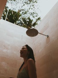 Portrait of young woman standing against wall under the water