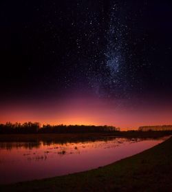 Scenic view of lake against sky at night