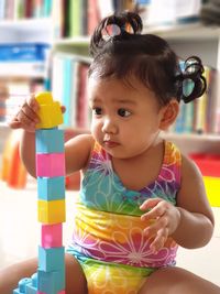 Portrait of cute baby boy sitting with toy