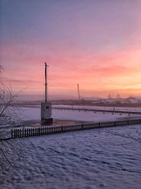 Pier over sea against sky during sunset