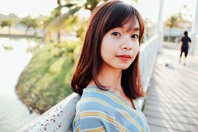Portrait of young woman on footbridge