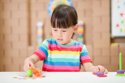 Young girl play magical magnet experiments at home for homeschooling