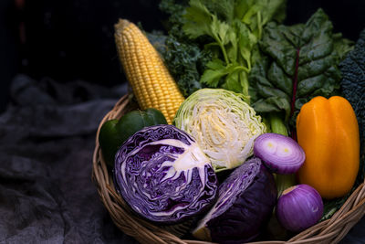 Salad in a wooden basket. carrots, corns, red onions, bell peppers, cauliflower, eggplant organic.