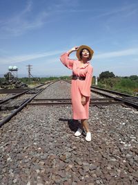 Portrait of woman standing on railroad track