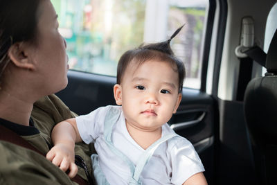 Mother with cute daughter sitting in car