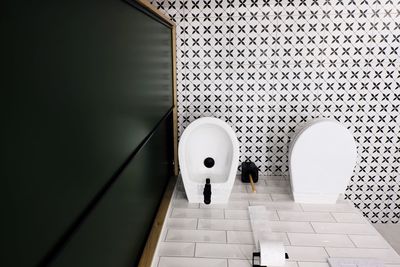 Top down view of a modern bathroom with dark green closet and retro style black and white floor