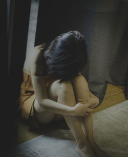 Woman sitting sad in a room