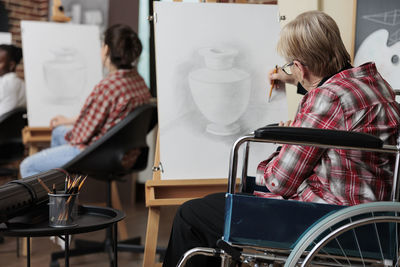 Senior woman sketching on artist canvas
