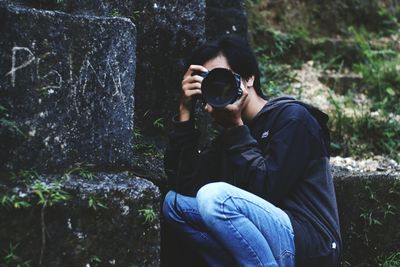 Full length of man photographing in forest