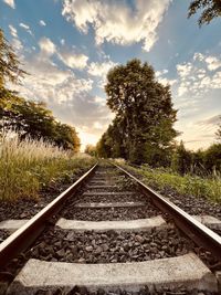 Railroad track against sky during sunset