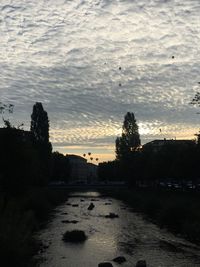 Scenic view of river against sky at sunset