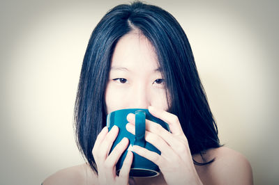 Portrait of beautiful young woman against white background